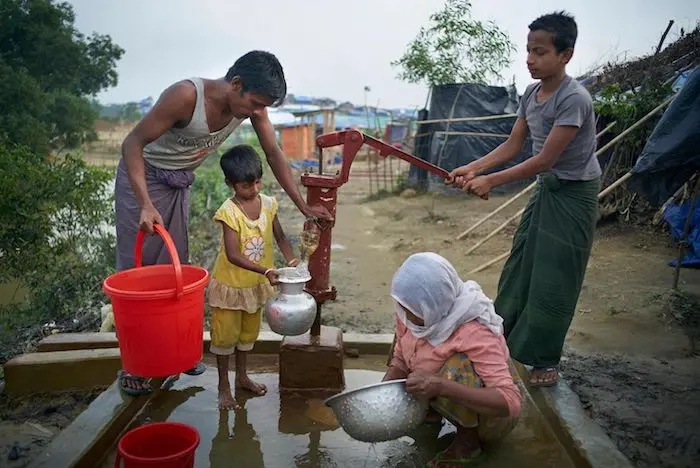 (Left) Fariduallah, 25, collects water from a community hand pump in the Madhu Chara area of Kutupalong makeshift settlement in Ukhiya Upazila, Cox’s Bazar District, Bangladesh,