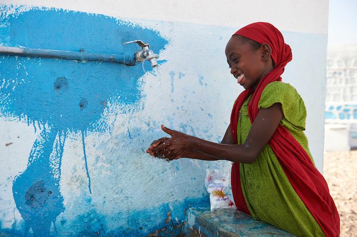 A girl wash her hands with soap and tap water outside a UNICEF-supported school in the village of Dafo, outside Tadjourah, southern Djibouti.