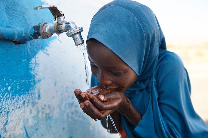 Since 2014, UNICEF has improved 51,000 schools’ water, sanitation and hygiene facilities and services for students like this girl who drinks safe water from a tap outside a UNICEF-supported school in Djibouti. © UNICEF/UN0199510/Noorani 