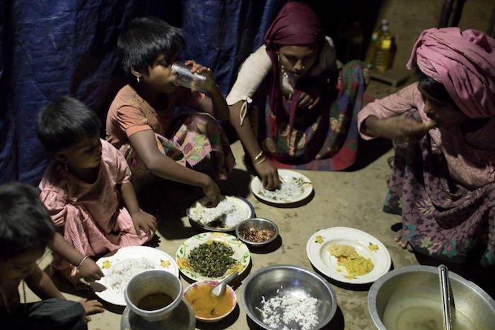 A family breaks sunset fast during Ramadan in Modurchara Camp 5, part of the sprawling Rohingya refugee settlement in Cox's Bazar, Bangladesh on June 4, 2018. 