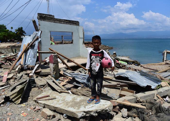 In Donggala, Central Sulawesi, Indonesia, 10-year-old Rido stands in front of his home, ruined by a tsunami in September 2018. 