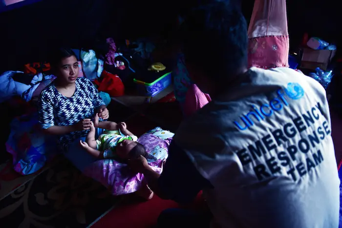 A UNICEF child protection officer helps a mother and her child seeking support after a devastating earthquake and tsunami in Palu, Sulawesi island, Indonesia.