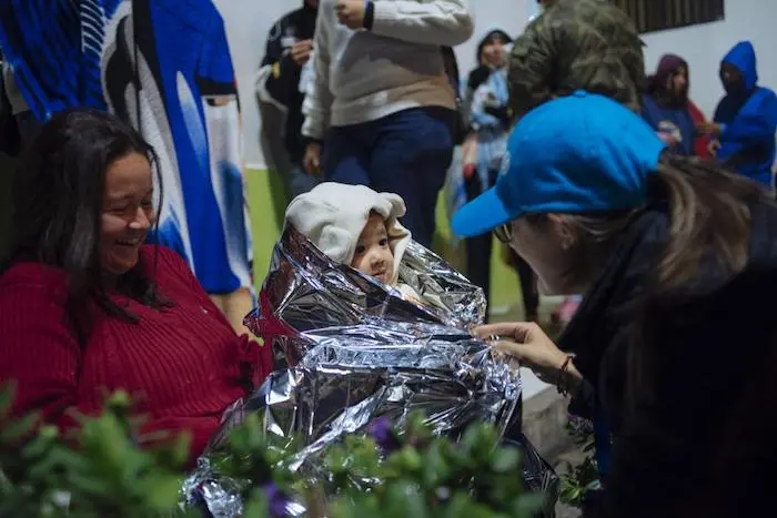 A UNICEF worker wraps a baby from Venezuela in a thermal blanket in Rumichaca, on the Ecuador/Colombia border.