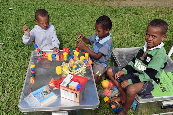Children in Alotau, Papua New Guinea explore the contents of a UNICEF School-in-a-Box kit in July, 2018.