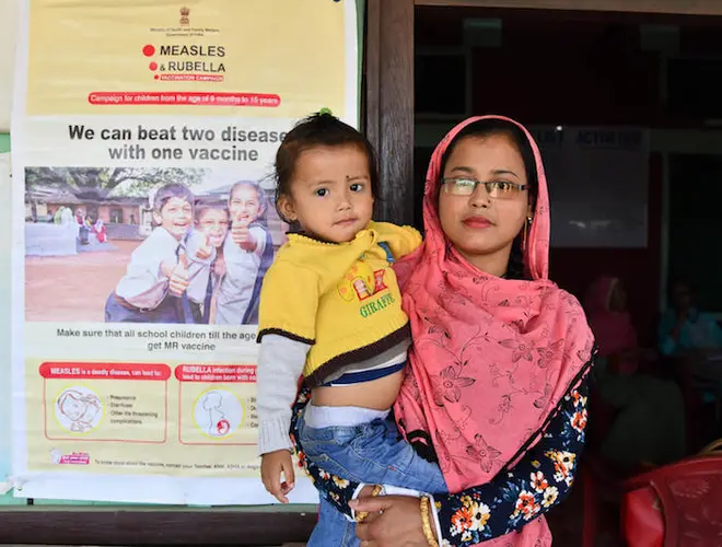 A mother brings her child to be vaccinated at a primary health center in Kwakta village, near Imphal in India's northeastern state of Manipur. 