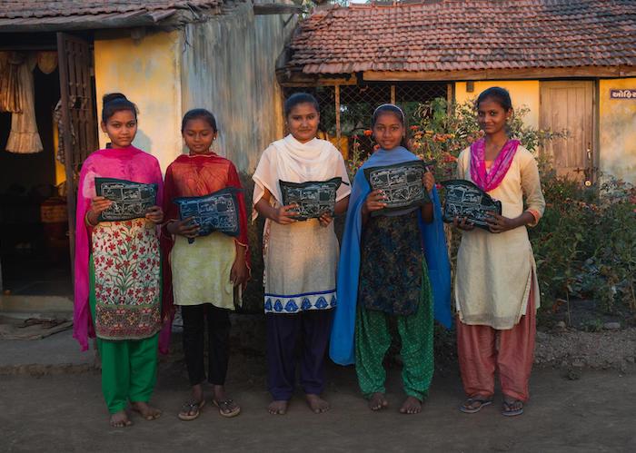 .Adolescent girls at a residential ashram school in Khamar Village in Gujarat, India hold menstrual hygiene kits they received from UNICEF partner organization Seva Rural.