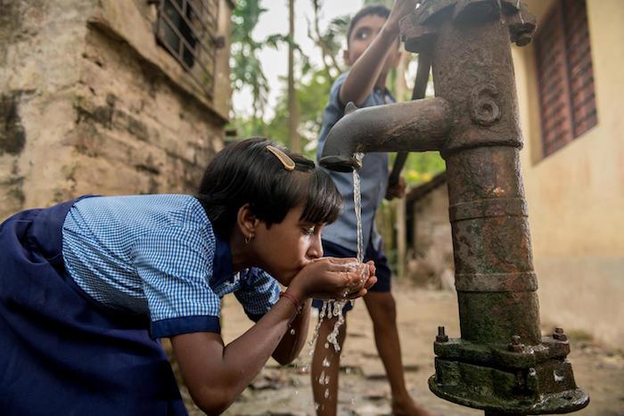  A girl drinks from a hand pump installed by UNICEF and partners in Gondharbapur village, West Bengal, India. 