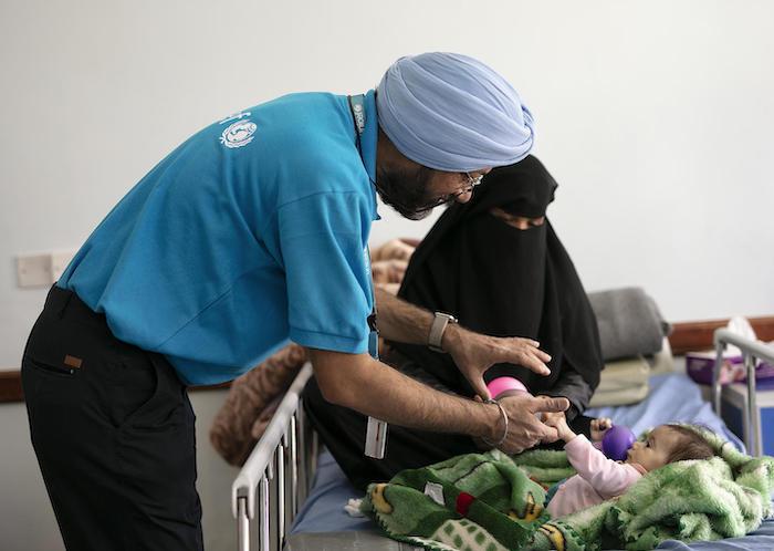 Karanveer Singh, UNICEF Yemen Nutrition Manager, cares for a severely malnourished baby in Sana'a, Yemen in October 2018.