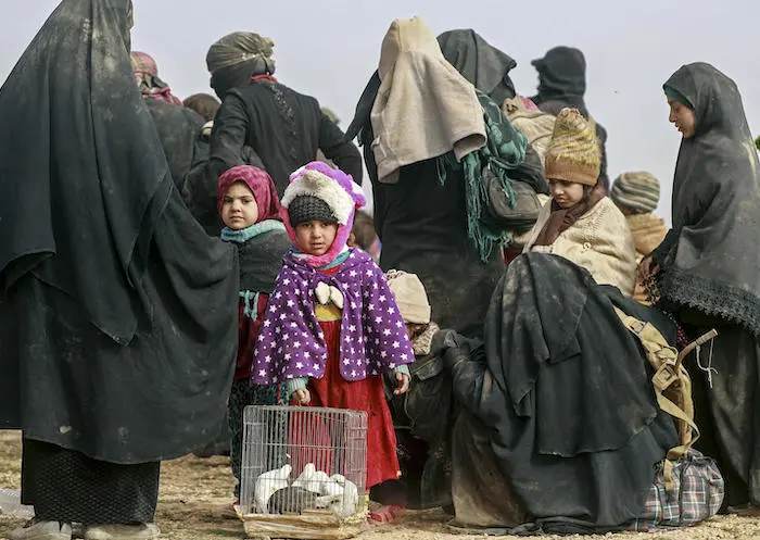 In January 2019, children and families huddle together after being forced to flee their homes in easter rural Deir-ez-Zor, Syria. 