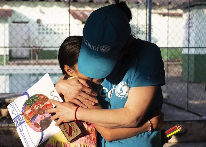 A UNICEF volunteer hugs a 10-year-old girl whose mother was killed by gang violence in Honduras. 