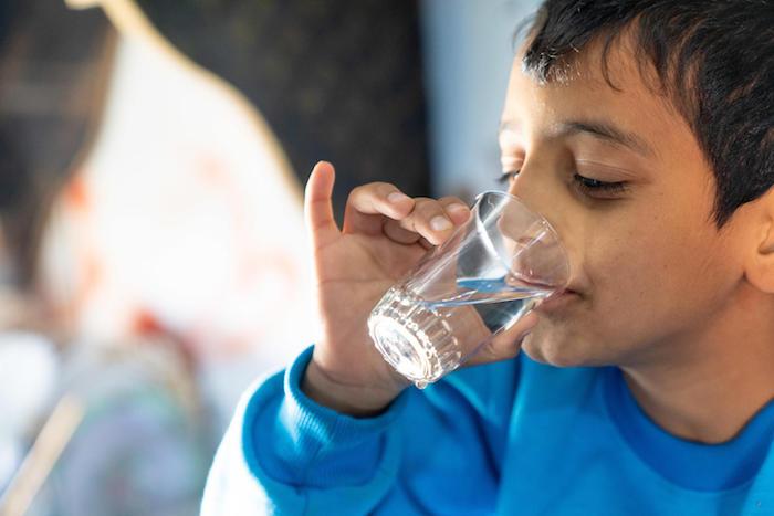 Syrian refugee Diaa, 10, drinks water from a tap installed by UNICEF and partners in Za'atari Refugee Camp, Jordan.