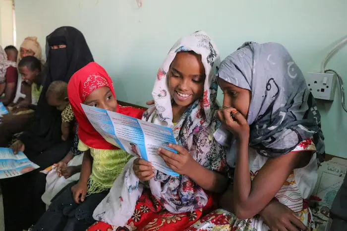 Girls in Aden, Yemen read through brochures while they wait to be vaccinated during a UNICEF-backed immunization campaign in February 2019.