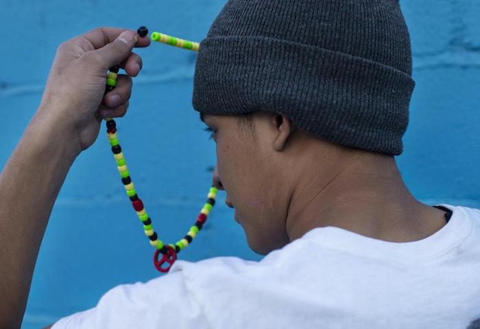 A 17-year-old from Guatemala staying at a shelter for unaccompanied migrant adolescents in Tijuana, Mexico holds the necklace his mother gave him for good luck on his journey north.