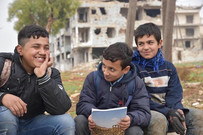 In Aleppo, Syria in 2019, Hussein and Mohammed are in school. Their friend Mustafa, 12, (right) dropped out to help support his family. 