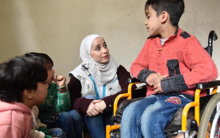 In Aleppo, Syria, a UNICEF-trained staffer talks with 11-year-old Abdullah, who was injured in a bomb blast that killed his father and brother. 
