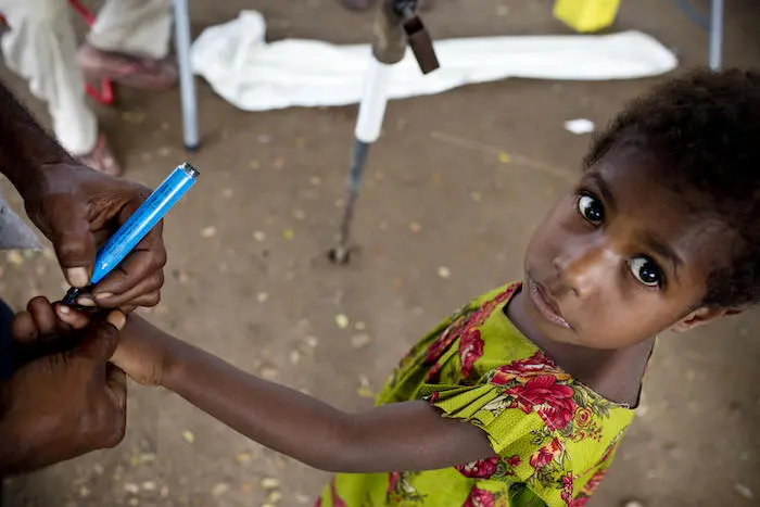 A young girl has her finger marked after receiving a UNICEF-supported polio vaccination in Angoram East Sepik Province, Papua New Guinea, in March 2019.