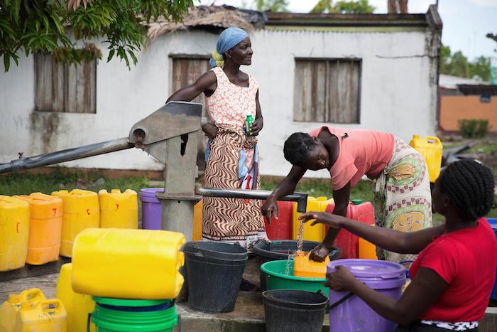 A woman puts drops of disinfectant into water to prevent cholera at a community water point in Dondo, Mozambique on April 14, 2019. 