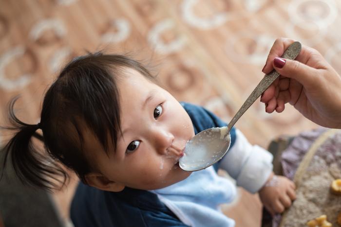 A child in Mongolia is given porridge mixed with micronutrient powders (MNP) to ensure proper nourishment.