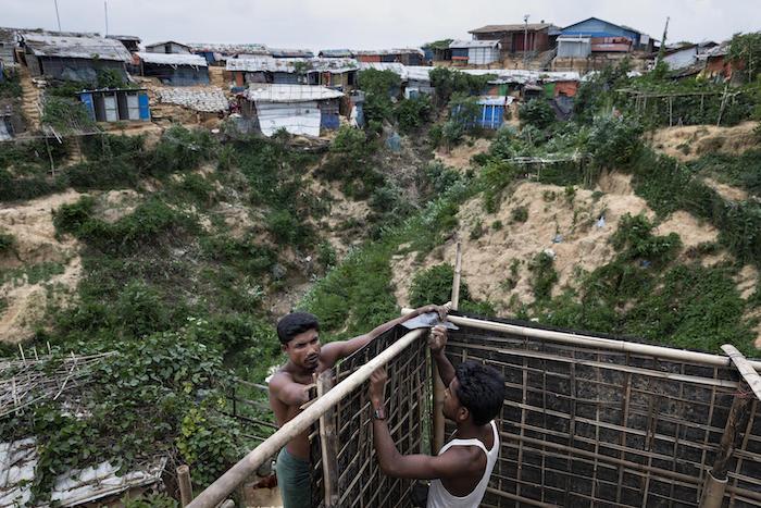 Imam Hosain (left), 27, and his brother Jahiruddin, 21, are building a family bathing room for both the females and males in their family in the hilly Hakimpara Rohingya refugee camp, Cox's Bazar, Bangladesh, June 2019. 