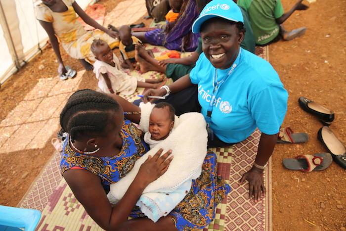 UNICEF staffer Cecilia Aldo visits with Anna Nyagma during a mother-to-mother community support group in South Sudan. Anna helps mobilize other mothers to join the meeting and practice exclusive breastfeeding.