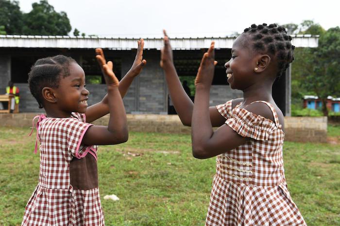 In Sangouine, Côte d'Ivoire, students play happily outside their new classrooms made of recycled plastic bricks through a UNICEF partnership with Conceptos Plasticos, a Columbian company. 