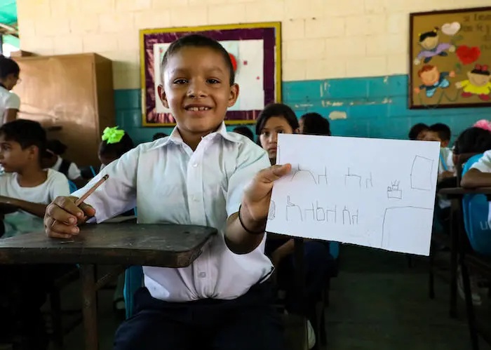 At Fe y Alegría school in Maracaibo, Venezuela in September 2019, Manuel, 8, drew a picture of his ideal classroom. UNICEF distributed backpacks full of school supplies on the first day of school. 