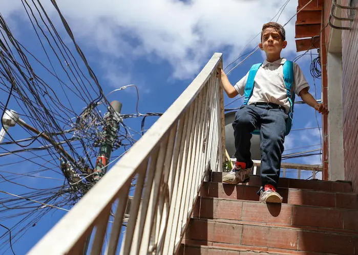 In September 2019, Luis, 9, rushes home to show his mother his UNICEF backpack in Baruta, Venezuela. Baruta has been severely affected by water and electricity shortages. 