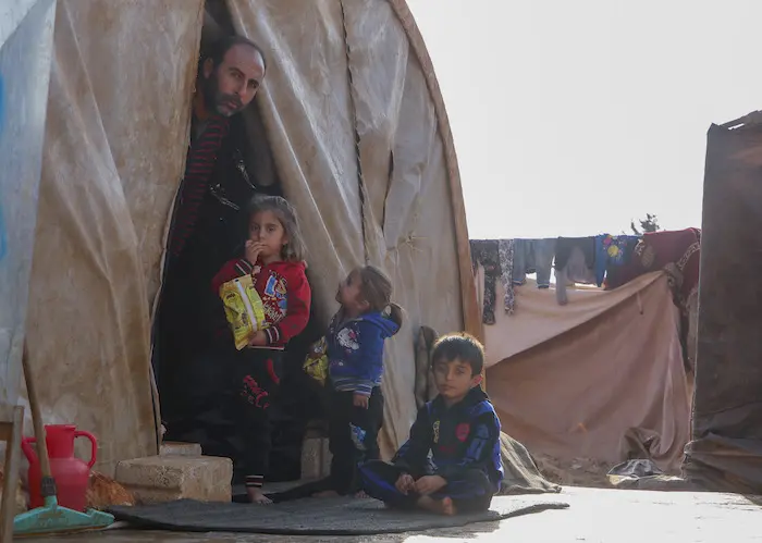 On November 16, 2019, a Syrian family displaced by violence shelters from the cold in an informal tented settlement in Killi, Idlib Governate, Syria, near the border with Turkey. 