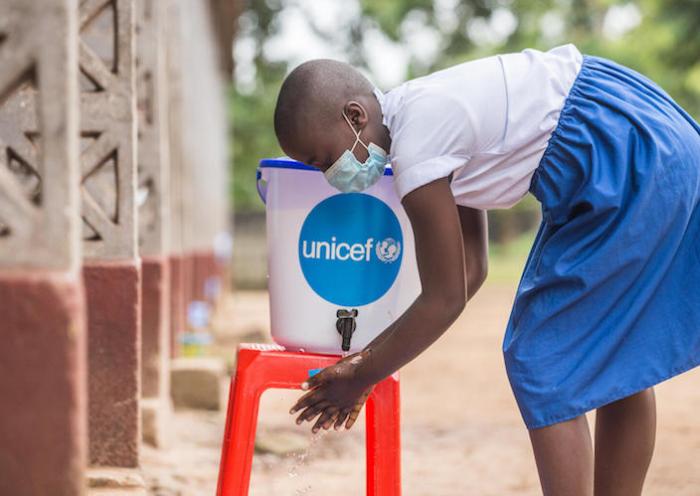 On November 10, 2020, a student washes her hands at a UNICEF-supplied hygiene station outside Elikya I Primary School in Mbandaka, Democratic Republic of Congo.