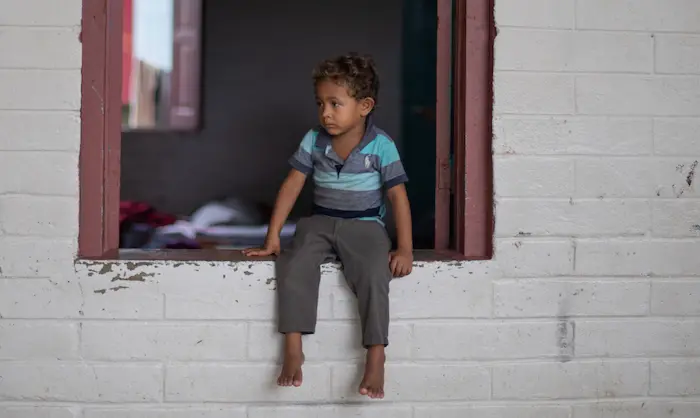 A boy whose family lost everything when Hurricans Eta and Iota swept through Honduras sits in the window of a school now serving as a shelter for affected families.