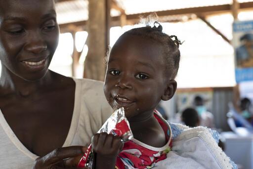 Jenty, 11 months old, eats Ready to Use Therapeutic Food in her mom’s arms at a UNICEF nutrition center in Yambio, South Sudan. When her mother brought her to the center, she was diagnosed with acute malnutrition. But after a several-week course of therap