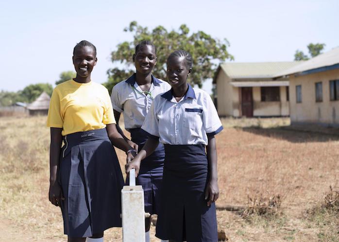 From left: Nite, 19, Elizabeth, 17, and Margaret, 17, stand beside a water borehole rehabilitated by UNICEF at Iluhum Primary School in Torit South Sudan. 
