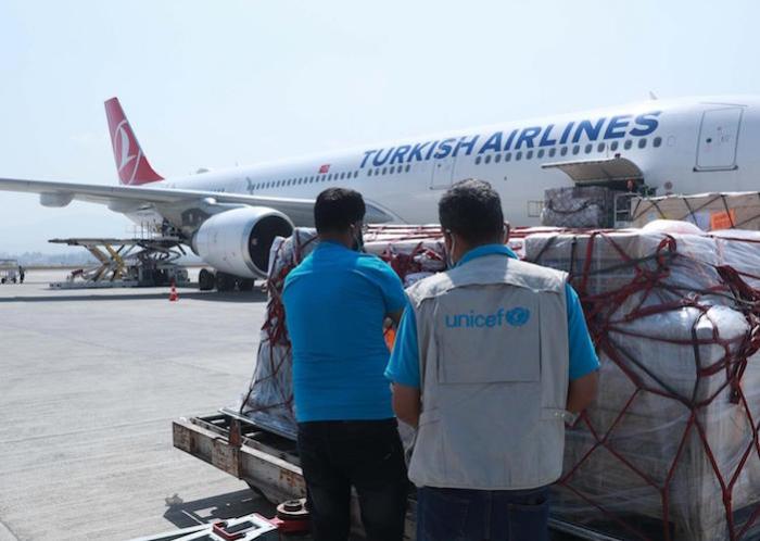 On March 11, 2021, UNICEF staff oversee the delivery of a COVAX shipment of syringes and vaccine safety boxes at the Tribhuvan International Airport in Kathmandu, Nepal. 