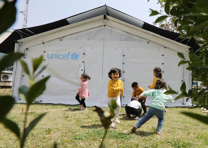 Children play inside and outside the new UNICEF High Performance Tents recently installed in Afghanistan to be used for community-based education programs.
