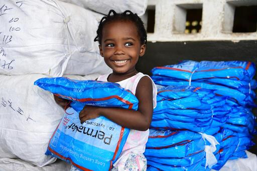 Marie, 2, receives mosquito nets with her father in Grand-Bassam, Côte d’Ivoire. A total of 19 million mosquito nets will be distributed to families to fight against malaria.