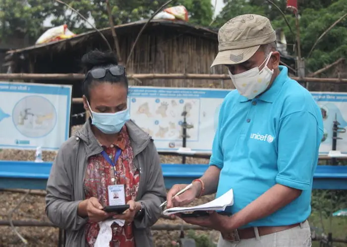 On May 5, 2021, a UNICEF staff member discusses COVID-19 health safety measures at the border crossing from India into Nepal at the Birgunj point of entry in Parsa District in southern Nepal. On May 5, 2021, a UNICEF staff member discusses COVID-19 health safety measures at the border crossing from India into Nepal at the Birgunj point of entry in Parsa District in southern Nepal.