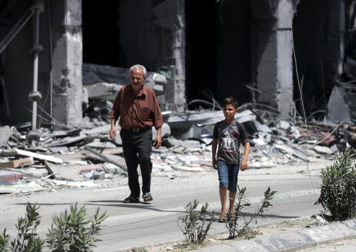 On May 17, 2021, a Palestinian family walks in front of a house that was targeted by the Israeli bombardment in Gaza City.