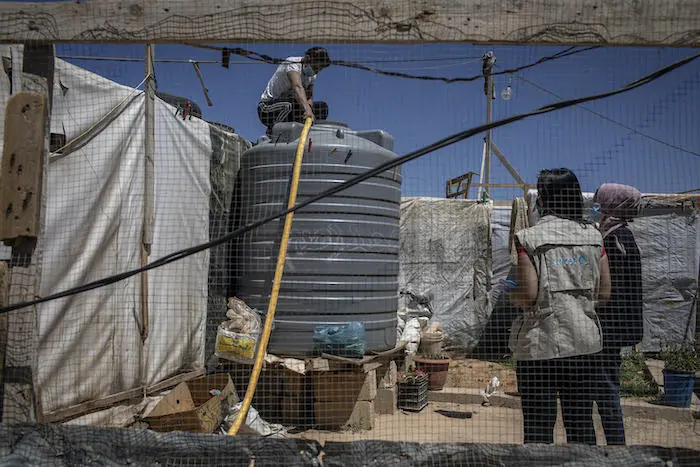 A UNICEF WASH team member monitors a water truck delivery in Iaat, north Lebanon, with WASH partner LOST on April 22, 2021.