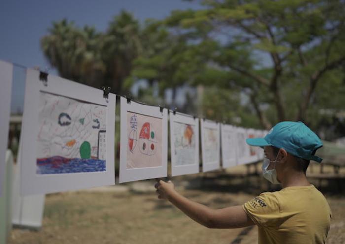 A boy admires artwork created by his peers and displayed in Beirut's Karantina Public Park on August 3, 2021, one year after a warehouse exploded near the Port of Beirut. 