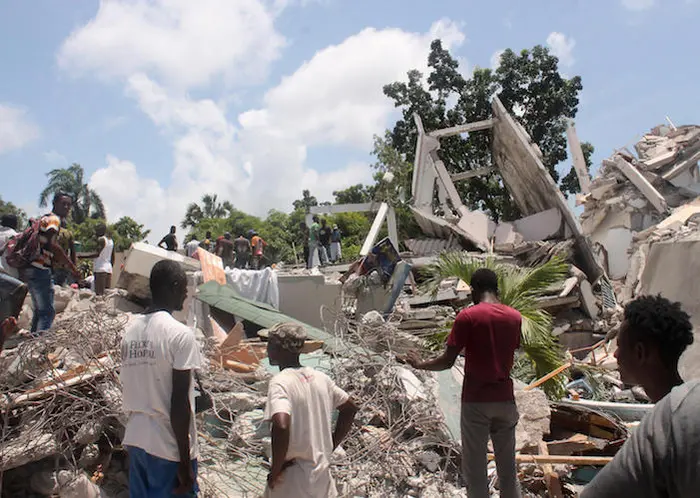 People search through the rubble of what used to be the Manguier Hotel after the earthquake hit on August 14, 2021 in Les Cayes, southwest Haiti.