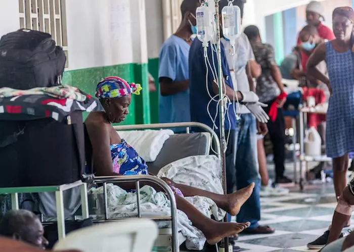An injured woman rests on a bed at a hospital in Les Cayes on August 15, 2021, after a 7.2-magnitude earthquake struck Haiti's southwest peninsula.