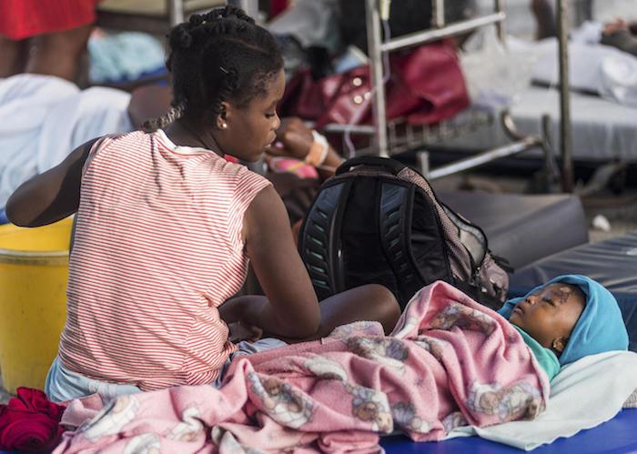 A young mother looks on at her daughter, injured as a result of the earthquake at the hospital "Communautaire de Référence" in Port-Salut, Haiti on August 16, 2021.