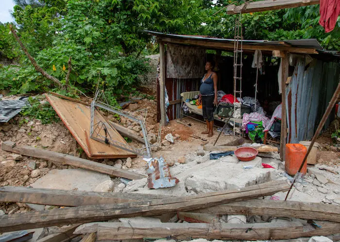 On August 16, 2021, Eline Duberice, seven months pregnant, stands in a temporary shelter built by her husband to protect her and their 2-year-old daughter from Tropical Depression Grace in Camp-Perrin, Haiti.