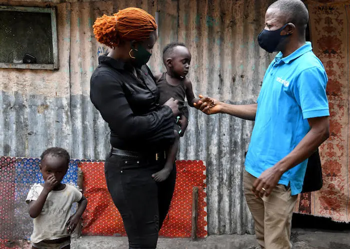 Sophie Bizeku, 33, and her family are beneficiaries of a cash assistance program to mitigate the soco-economic impact of COVID-19 in the Democratic Republic of Congo. Sophie Bizeku, 33, speaks with a UNICEF staff member in Moro, a suburb of Kinshasa in the Democratic Republic of Congo.