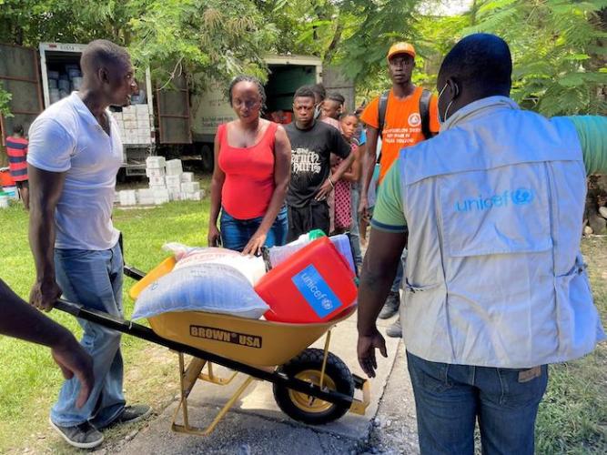 Locals pitch in to help transport hygiene kits from UNICEF in Les Cayes, one of many areas of Haiti where poor access to safe water, sanitation and hygiene increases health risks for children.