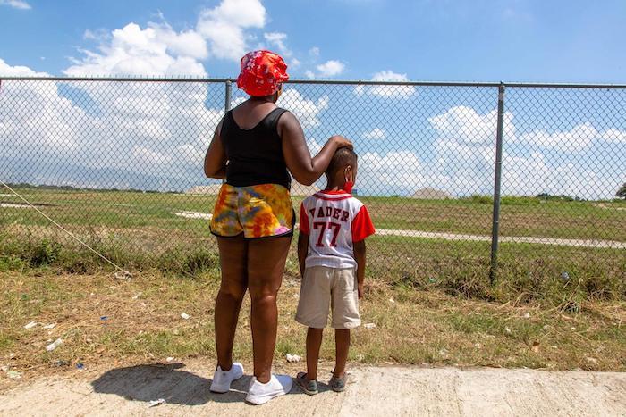 A mother and son look out over the airfield at Port-au-Prince airport after being returned from the U.S. border.