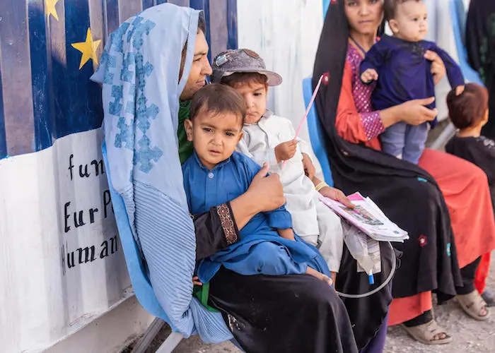 A mother and her children wait for their turn for a health and nutrition screening at a UNICEF- and WFP-supported Mobile Health Team clinic at Sabz-e-Shark IDP settlement in Herat, Afghanistan on September 29, 2021.