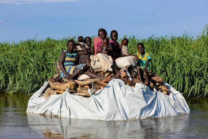 In Upper Nile, South Sudan, a family displaced by flooding floats down the Sobat River, in search for higher ground. 