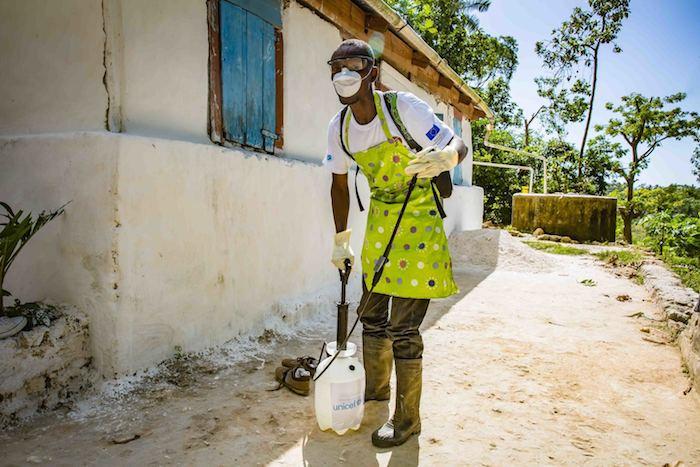 A member of a cholera rapid response team in Haiti prepares to disinfect a residential area suspected of being contaminated with disease-causing bacteria.