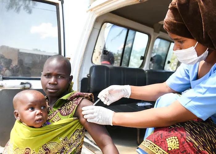 Naomi Phiri, 19, holds her baby daughter, Madalitso, as she gets her first dose of COVID-19 vaccine in Chiwinga village, central Malawi on December 14, 2021. Naomi Phiri, 19, holds her baby daughter, Madalitso, as she gets her first dose of COVID-19 vaccine in Chiwinga village, central Malawi on December 14, 2021.